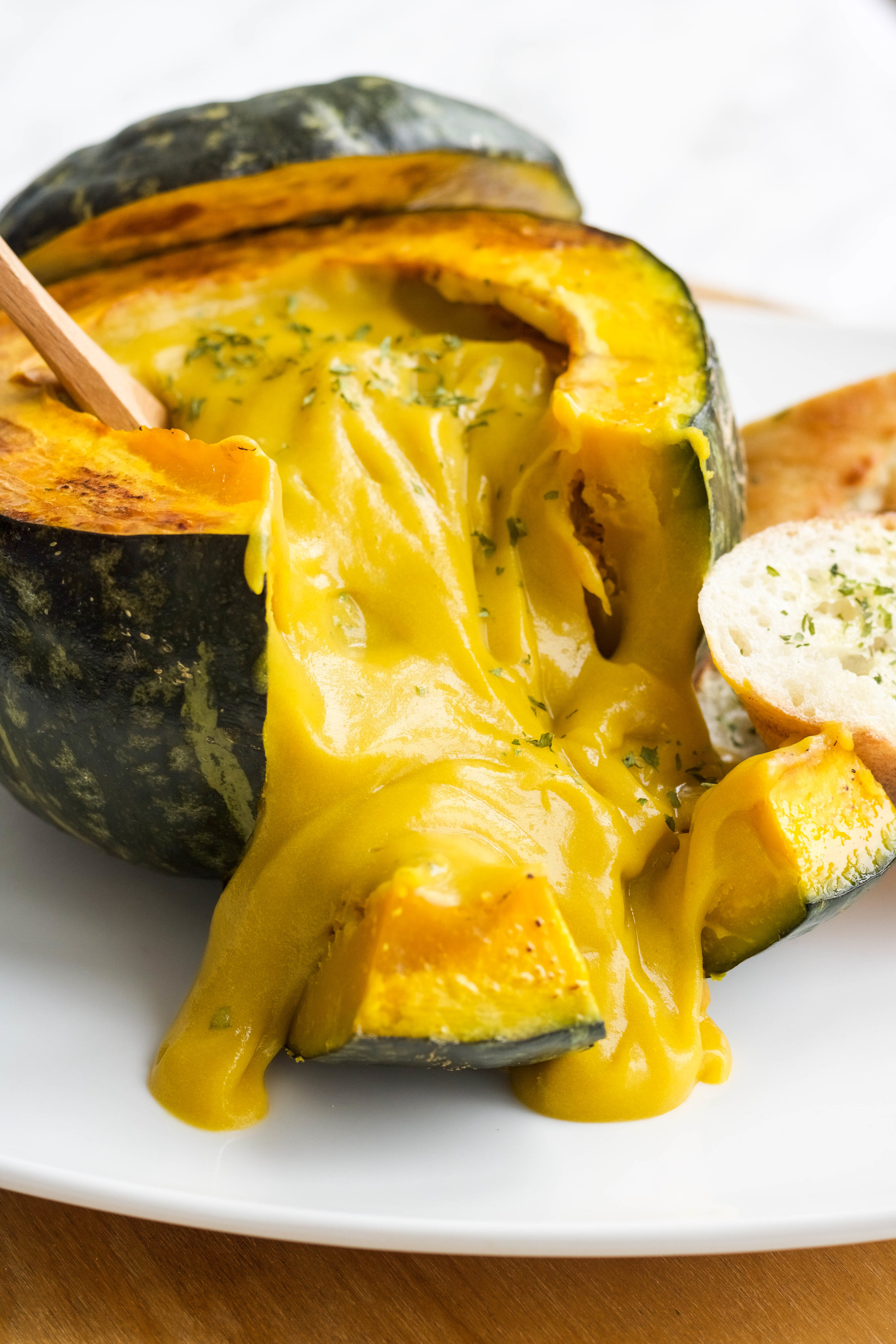  Ingredients:  1 small onion  1 med potato (around 150g)  1/2 carrot (approx 40g)  1.5 lbs kabocha squash*  2 c + 1/4c veg stock  1 c soy milk**  Optional: Additional squashed to make kabocha bowls  Method:  1. If making kabocha bowls, pre-heat oven to 350  2. Cut upper half of the squash and discard the seeds  3. Place on a baking tray and place in oven for 30 minutes  4. Chop up the onion, carrot, potato and kabocha into small pieces  5. Sautee the onions lightly  6. Add in the carrots, potatoes and kabocha and let it sautee for a few minutes  7. Add in the veggie broth and let it come to a boil and then reduce to a simmer for approx 40 minutes or until you can mash the potatoes and kabocha with a fork  8. Remove from heat and let it cool  9. Once slightly cooled, transfer to a blender and add soy milk  10. Pour it into the kabocha bowls and serve with toasted garlic baguettes!      Notes:  1. Buttercup squash may be substituted   2. Add more for a thinner consistency! 