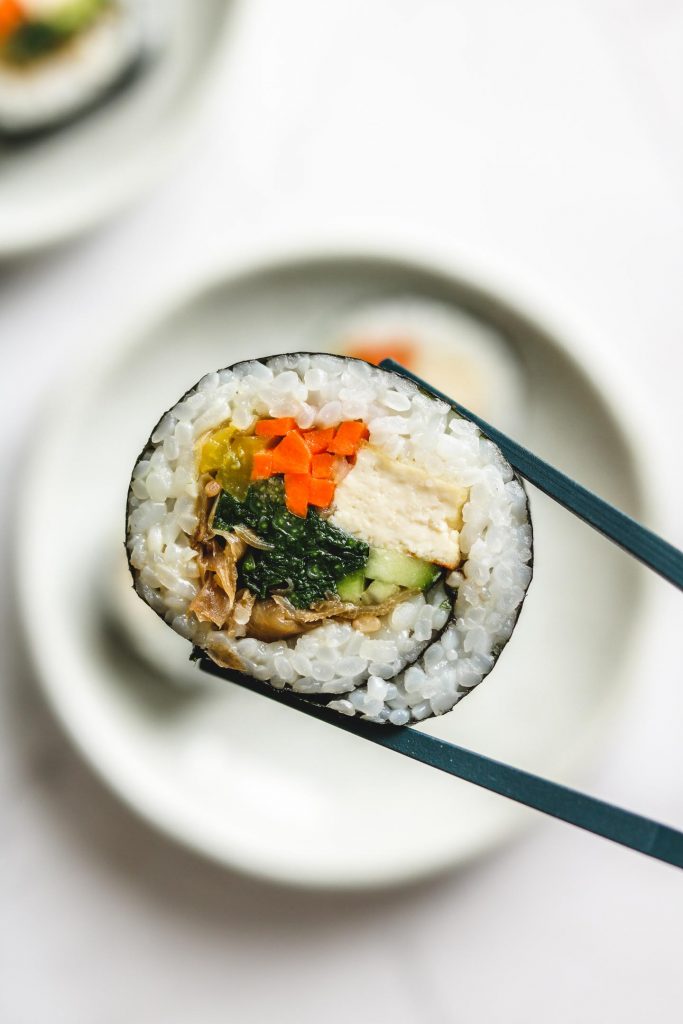 vegan kimbap holding with chopstick