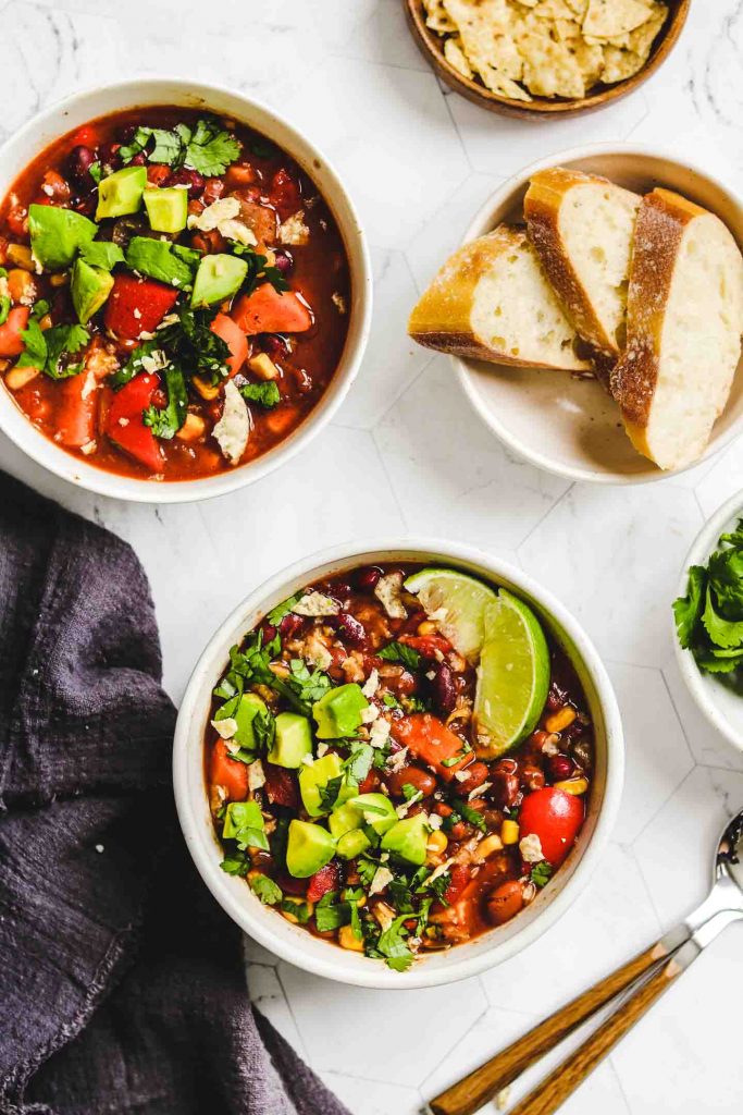 Instant Pot Vegan Chili in two white bowls with bread