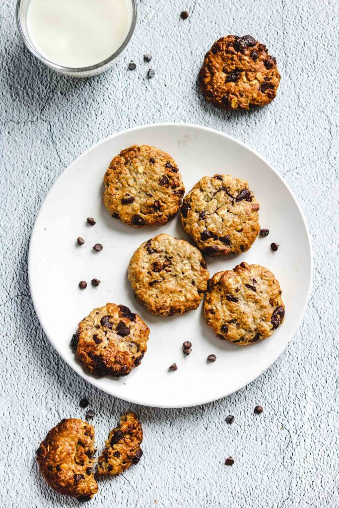 Air Fryer Tahini Chocolate Chunk Oatmeal Cookies on a white plate with a glass of milk