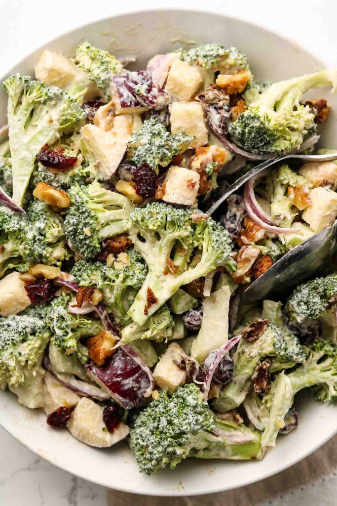 vegan crunchy broccoli salad with dairy free dressing in a shallow bowl close up shot
