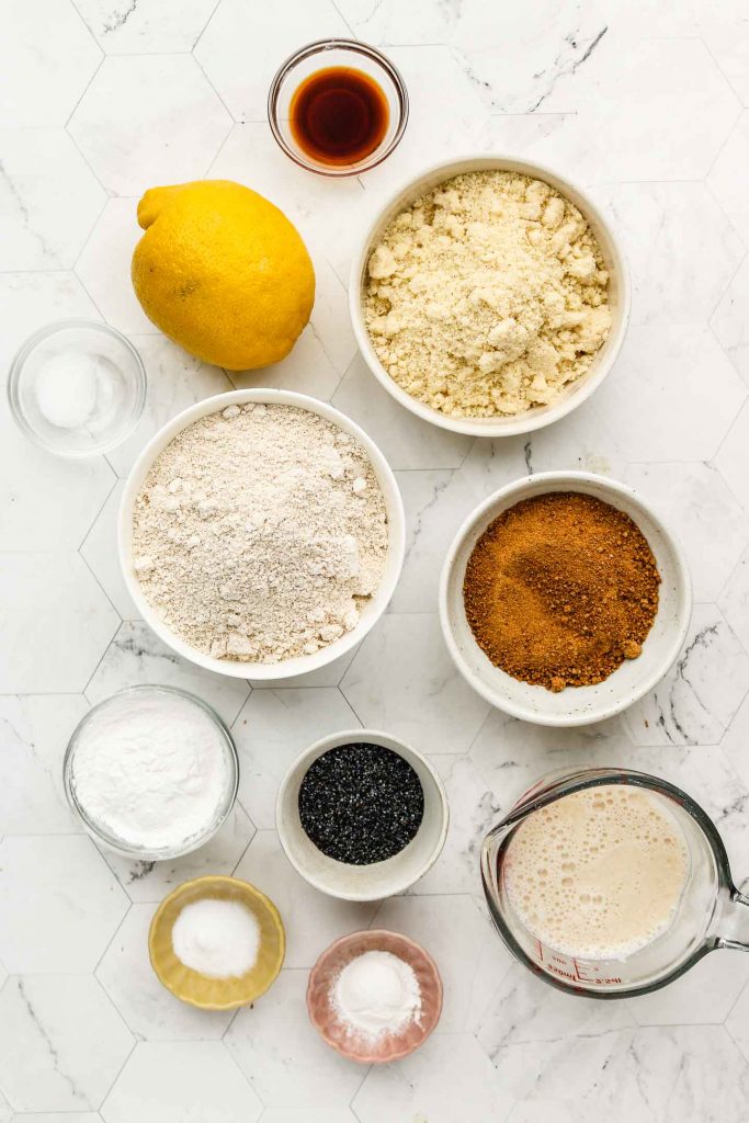 ingredients for vegan lemon poppy seed muffins on a marble backdrop