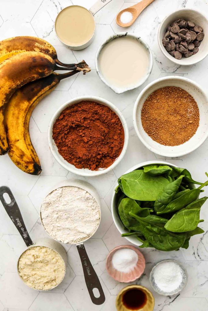 ingredients for green smoothie banana chocolate muffins on a marble top