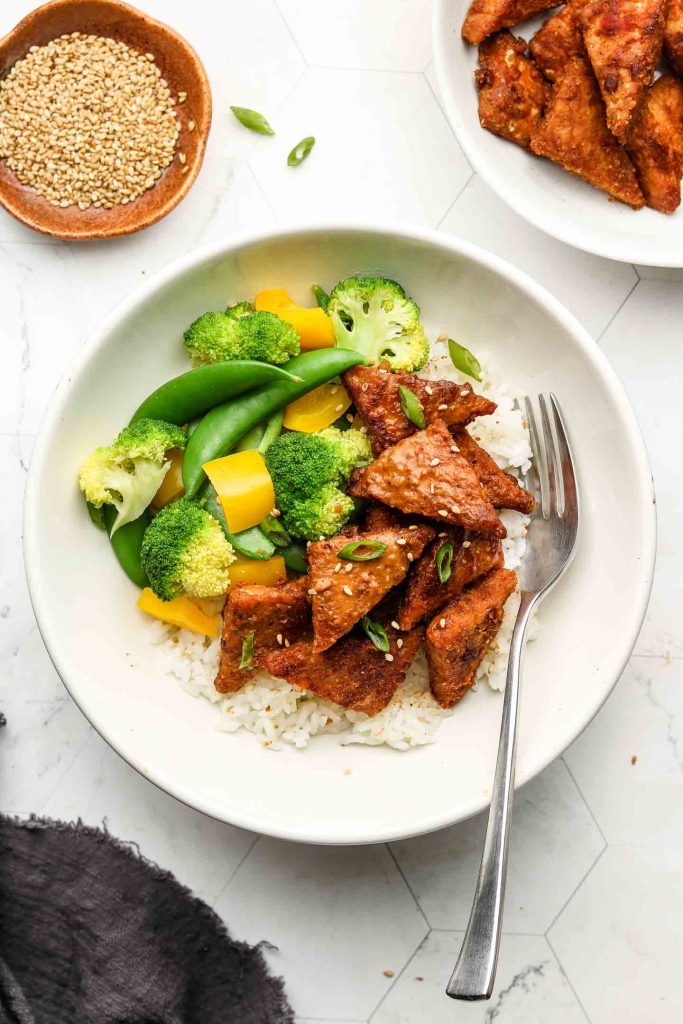 marinated peanut tempeh in a rice bowl with vegetables
