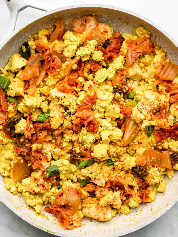 scrambled tofu with kimchi in a white speckled pink pan