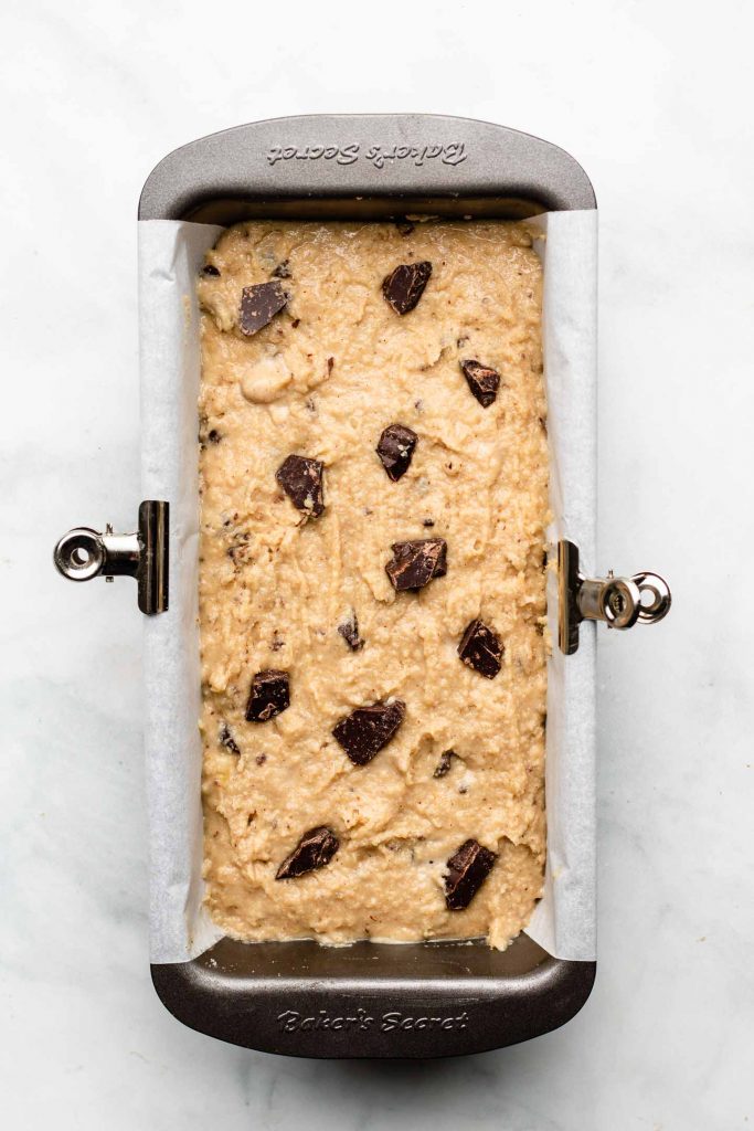 paleo banana bread batter in a 8x4 inch baking tin with chocolate chips