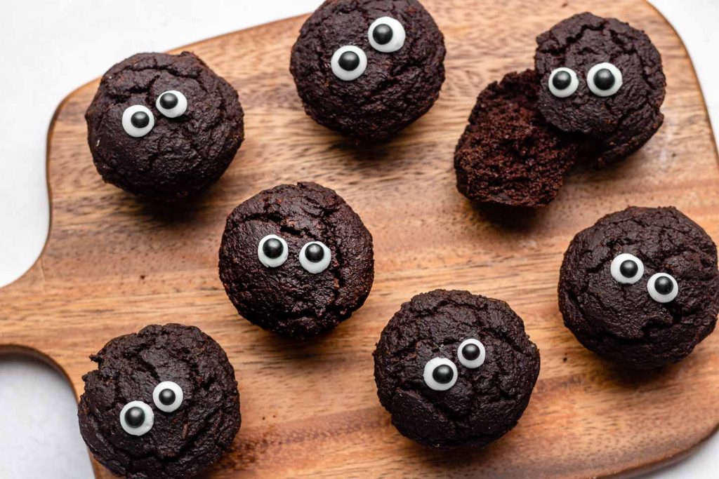 brownie bites with googly eyes on a wooden cutting board