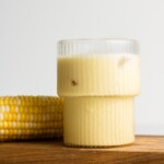 corn milk in a mushroom cup with cob beside it