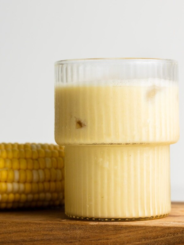 corn milk in a mushroom cup with cob beside it