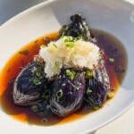 japanese eggplant in savory broth in a white bowl