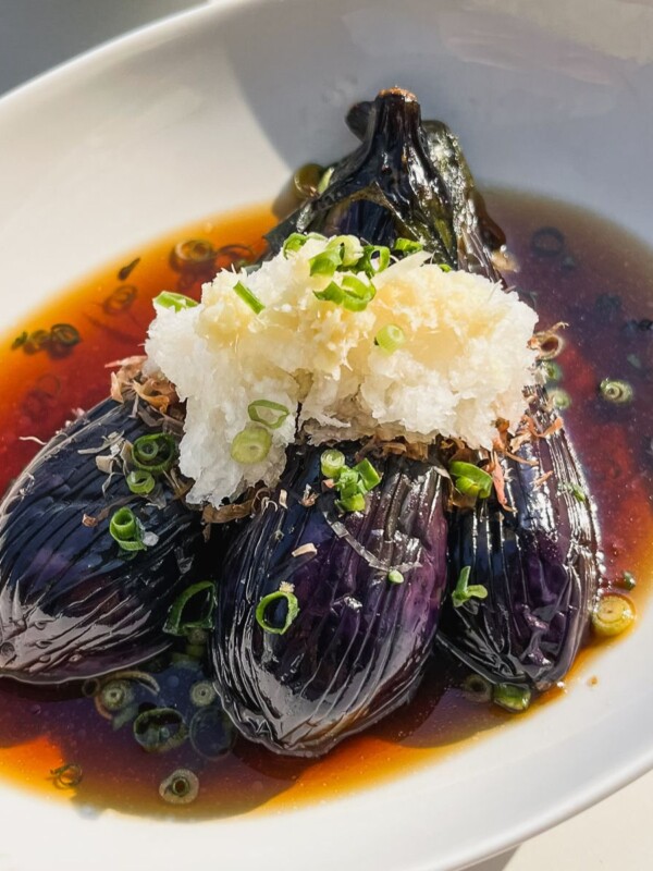 japanese eggplant in savory broth in a white bowl